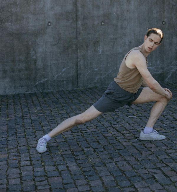Man stretching outdoors at sunrise, feeling energized and refreshed.